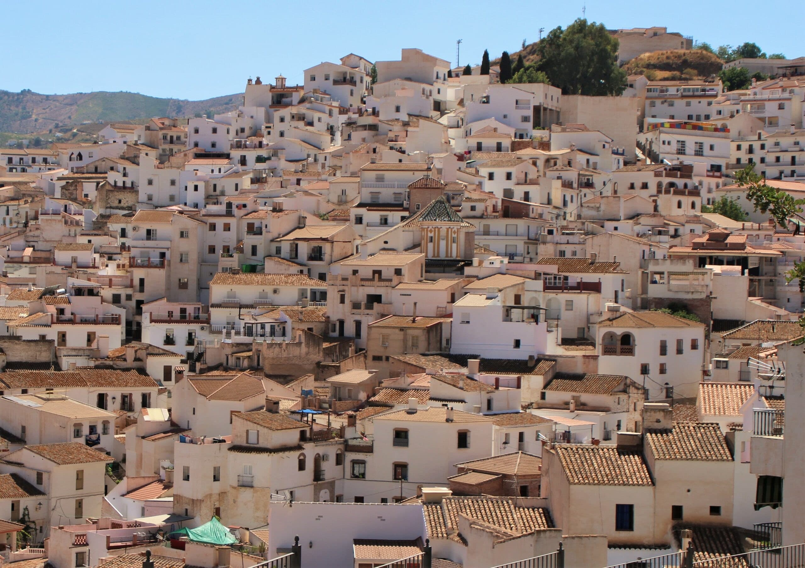 Casco urbano de Almáchar, con sus casas blancas escalonadas en la ladera y la torre de la iglesia de San Mateo
